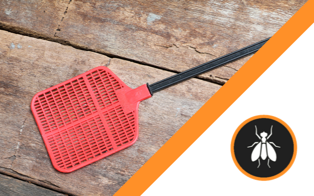 A red fly swatter is sitting on a wooden table