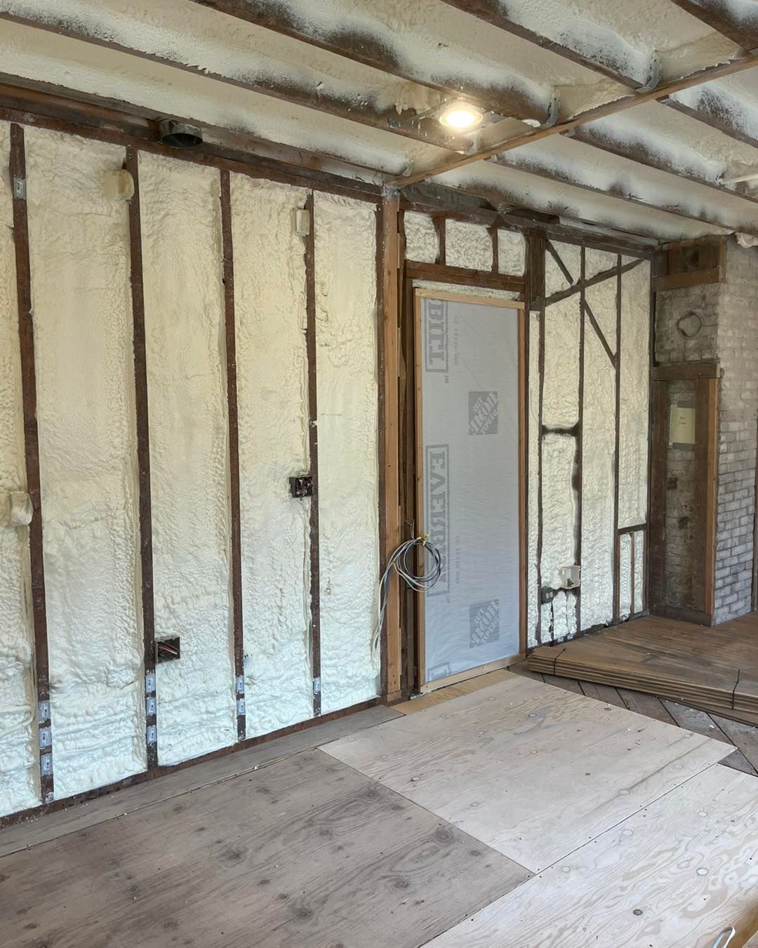 A room with foam insulation on the walls and a door.