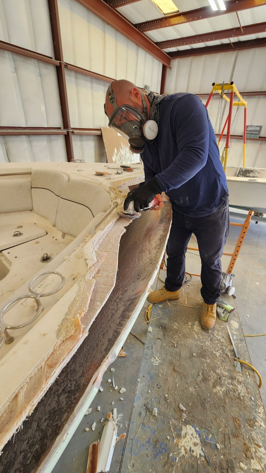 A man working on a boat with tools.