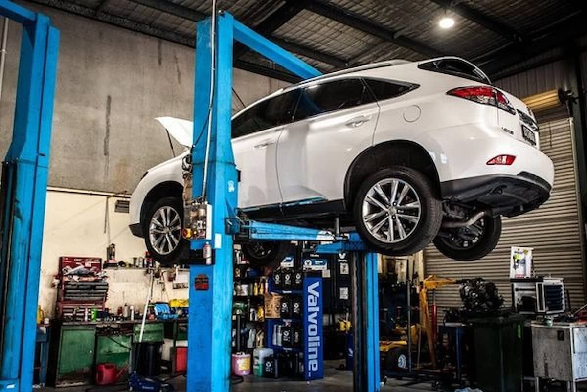 White Suv Raised on A Blue Car Lift in An Auto Repair Shop โ DK Mechanical Repairs in Warners Bay, NSW
