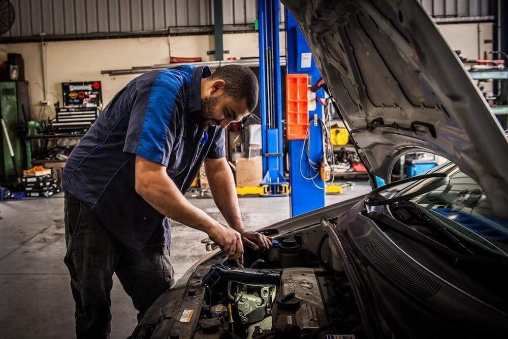 Mechanic Working on A Car Engine in A Garage — DK Mechanical Repairs in Warners Bay, NSW