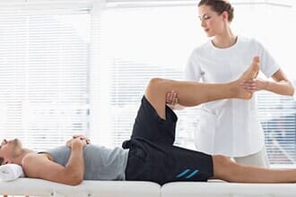 Therapist massaging leg of man — Sports Physical Therapy in Old Bridge, NJ