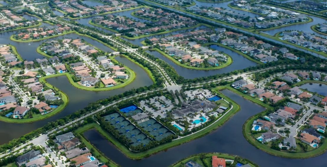 Aerial view of a suburban neighborhood with houses, canals, and roads.