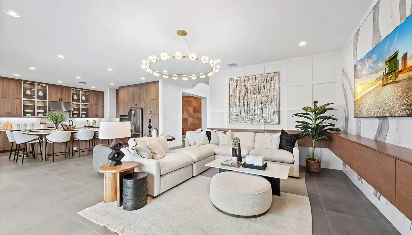 Open-concept living space with a kitchen, dining area, and living room. Neutral colors and modern furniture.