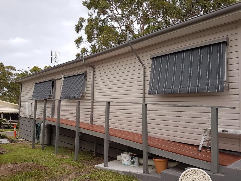 A House With a Ramp and a Ladder on the Side of It — Design 2000 Blinds & Awnings In San Remo, NSW