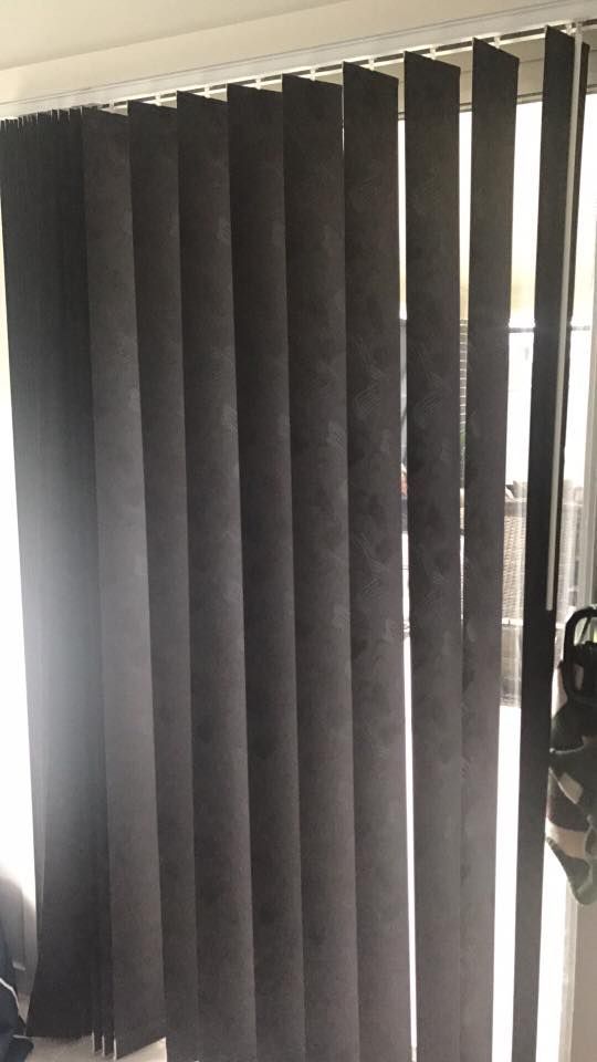 A Pair of Black Vertical Blinds Are Hanging on a Window — Design 2000 Blinds & Awnings In San Remo, NSW