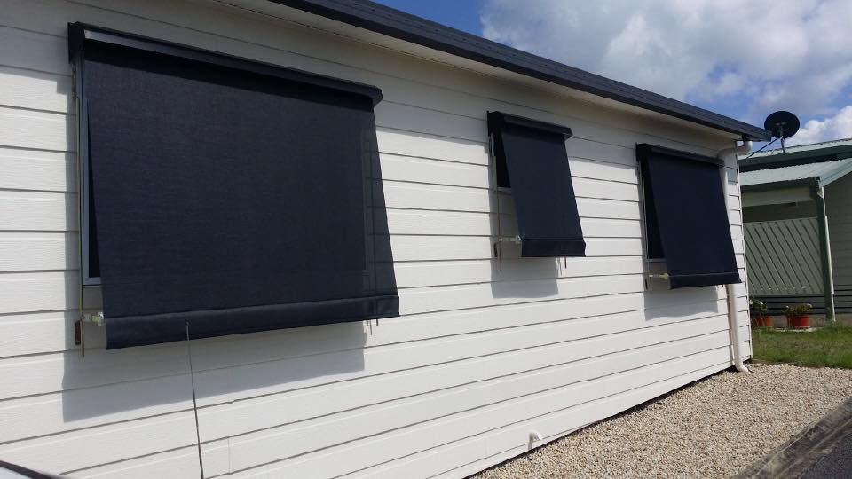 A White House With Black Blinds on the Windows — Design 2000 Blinds & Awnings In San Remo, NSW