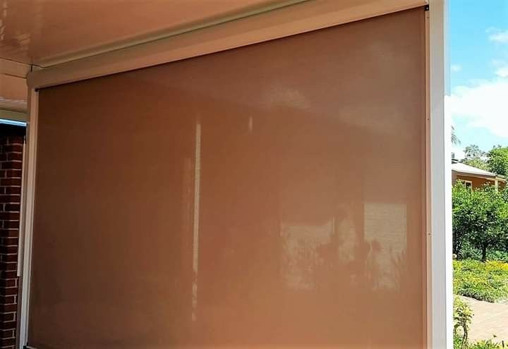 A Large Window With a Brown Blind on It — Design 2000 Blinds & Awnings In San Remo, NSW