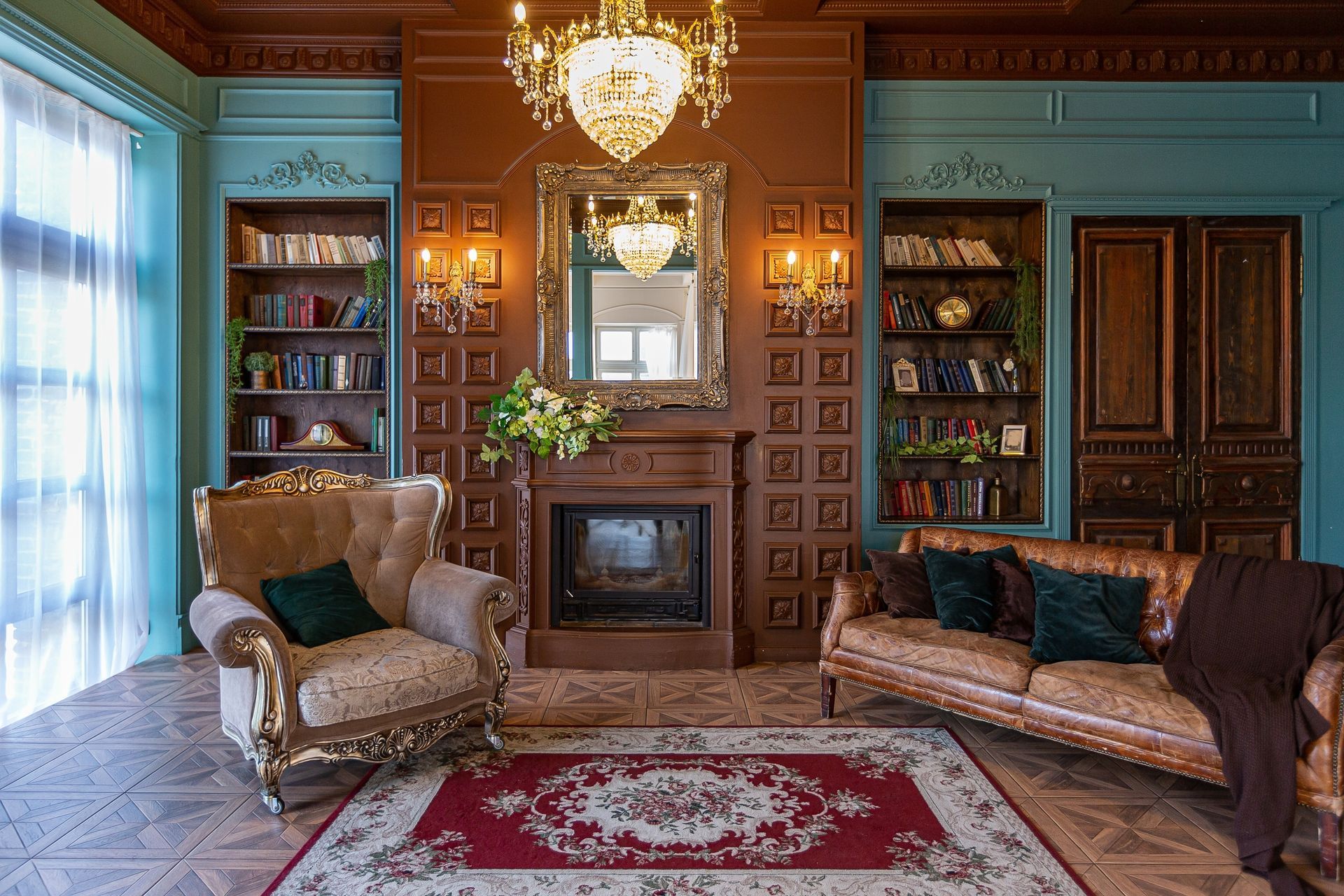 A living room with a couch , chair , fireplace and chandelier.