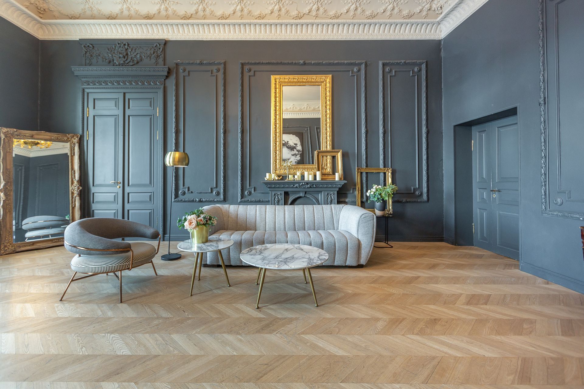 A living room with a couch , chair , coffee table and mirror.