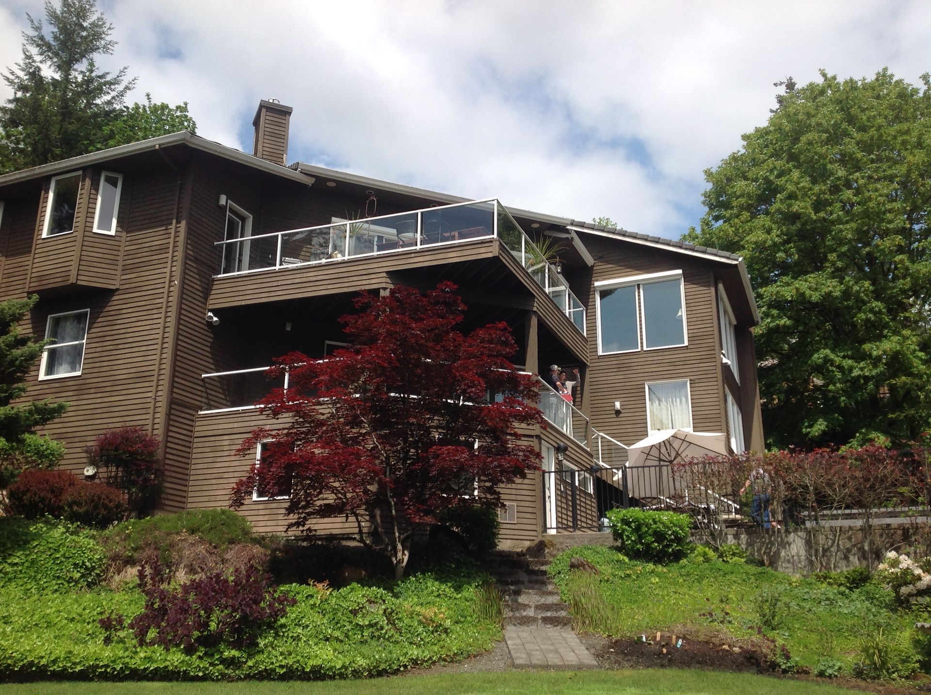 A large house sits on a lush green hillside