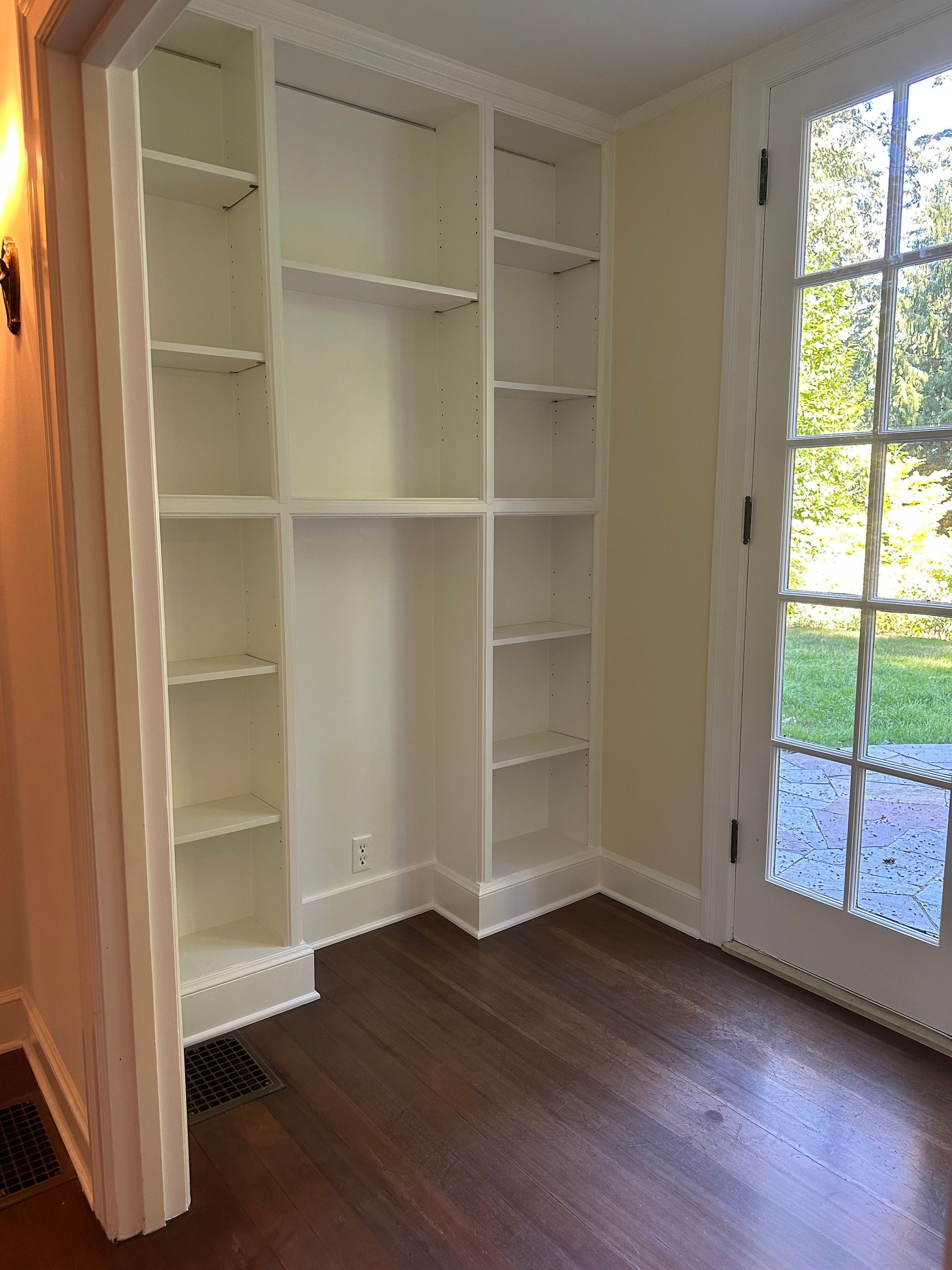 A room with white shelves and a sliding glass door