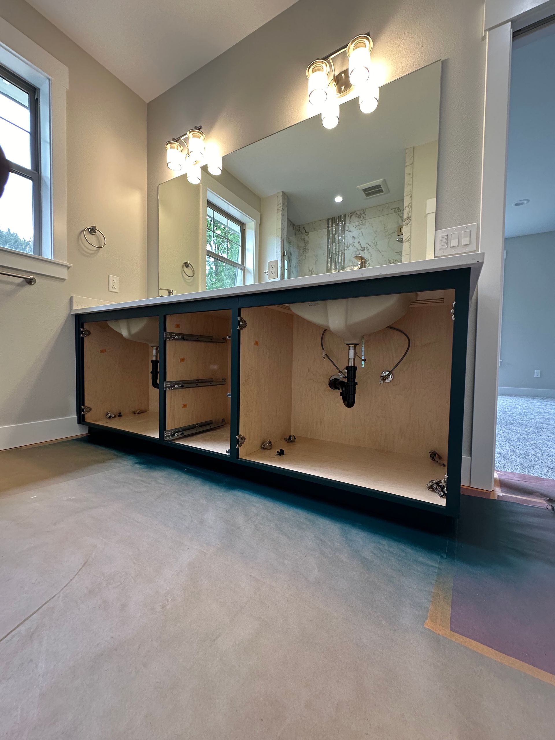 A bathroom with a sink , mirror and cabinets.