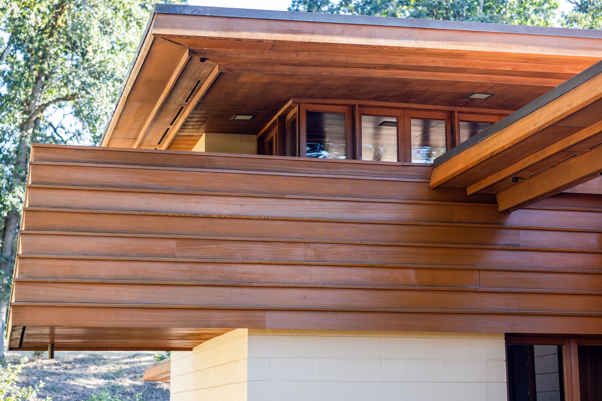 Exterior of a modern house with horizontal wooden siding and a flat, overhanging roof.