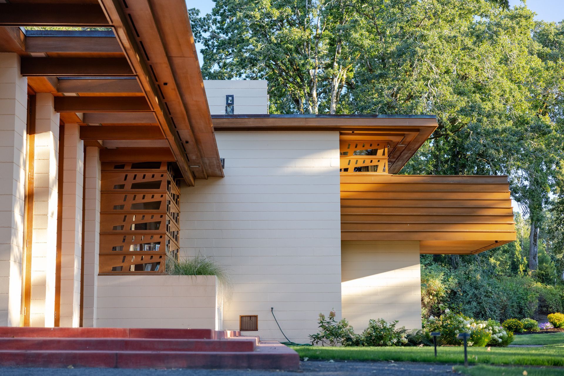 Beige and brown modern home exterior with overhanging eaves and patterned wooden accents.
