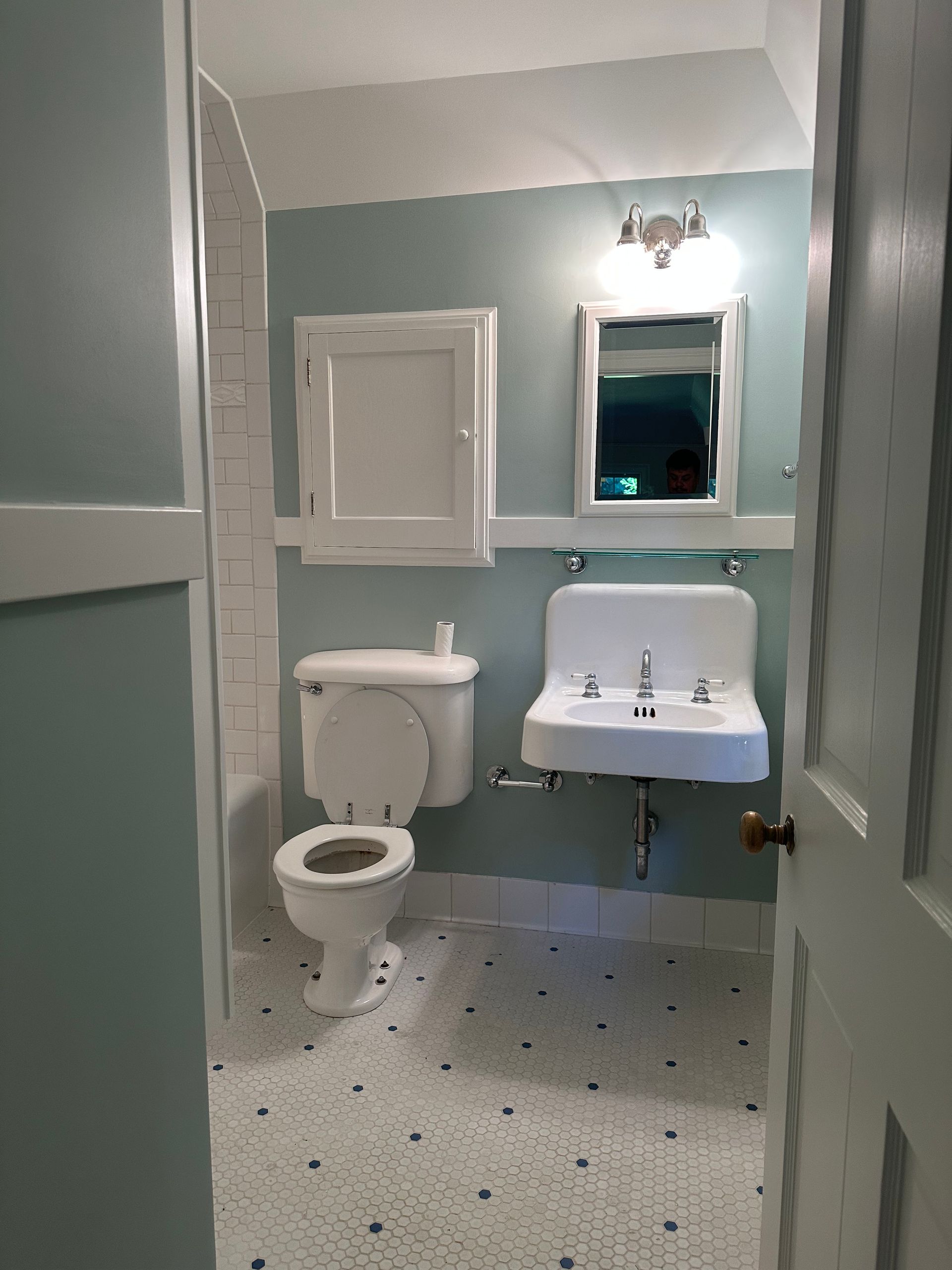 A bathroom with a toilet a sink and a mirror