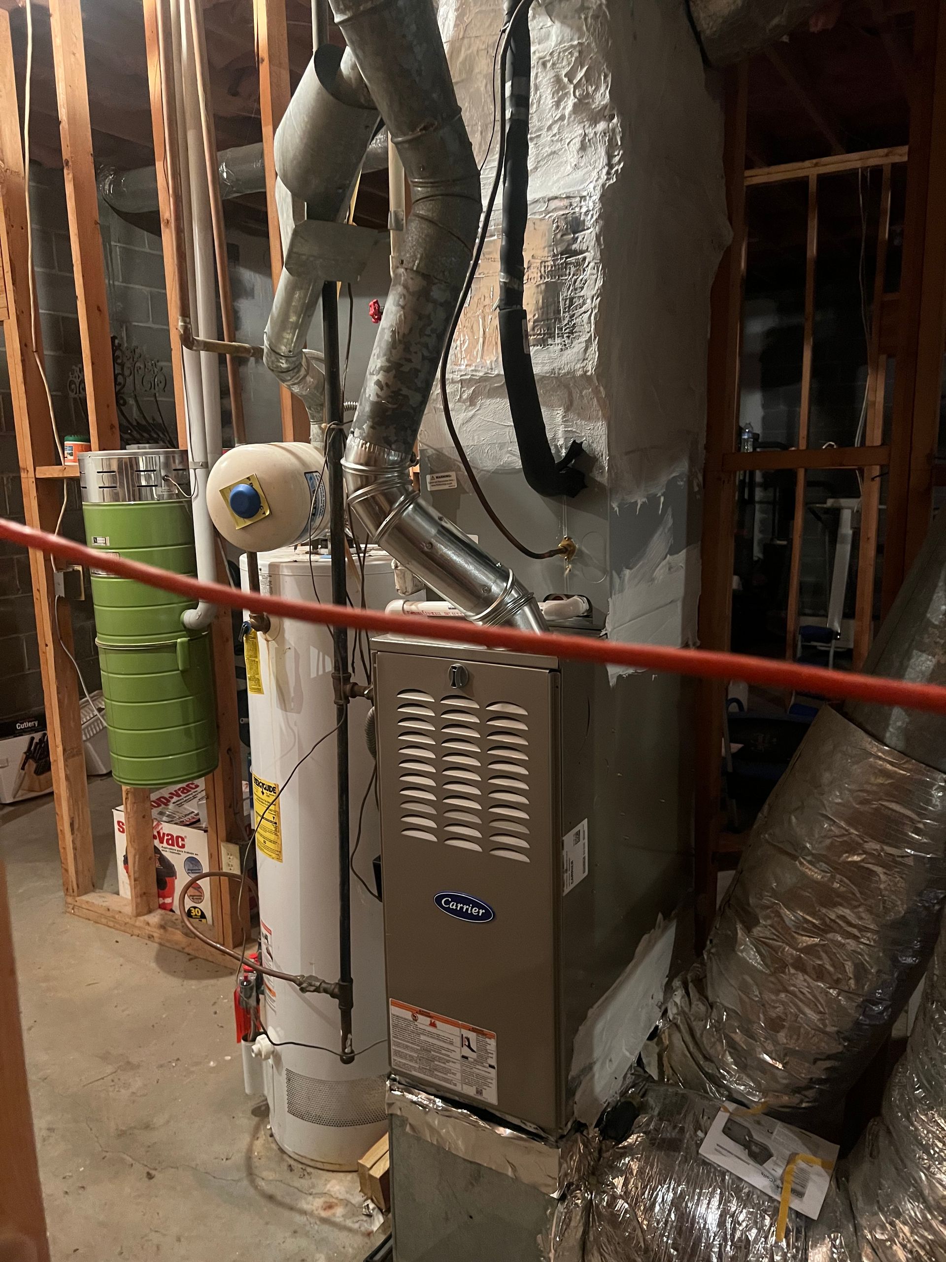 Furnace, water heater, and other HVAC components in a basement setting.