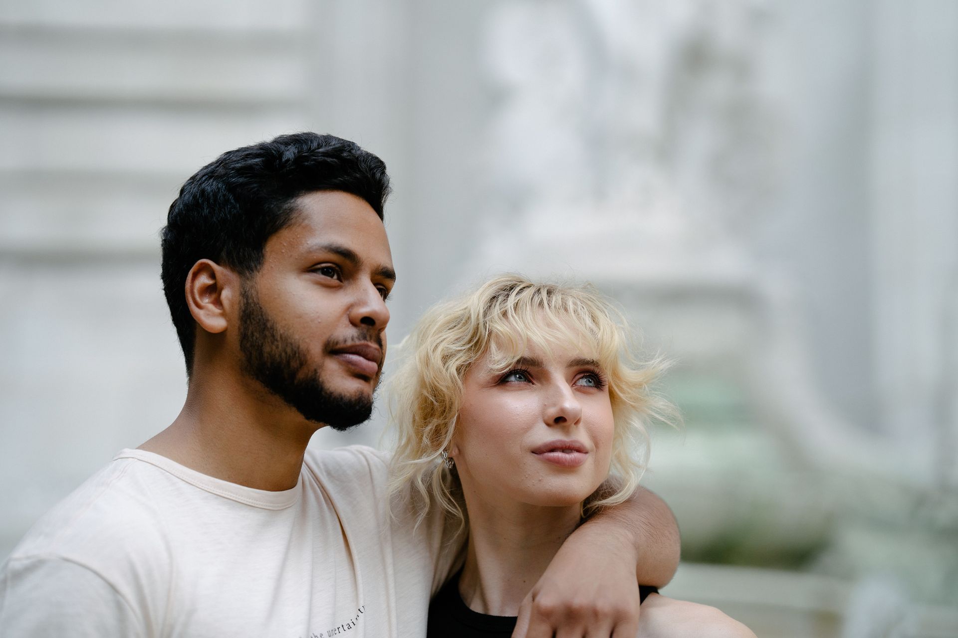A bi-racial couple with their arms around each other work on shifting their perceptions during a Couples Retreat in Florida. Learn more about Hold Me Tight® workshops in Flordia, Georgia, North Carolina, and beyond here and strengthen your marriage therapy!