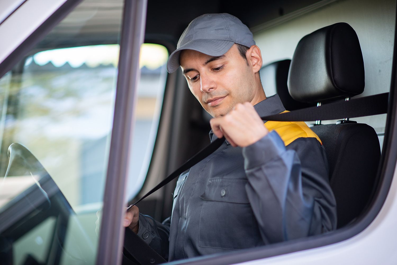 A man is putting on his seat belt in a van.