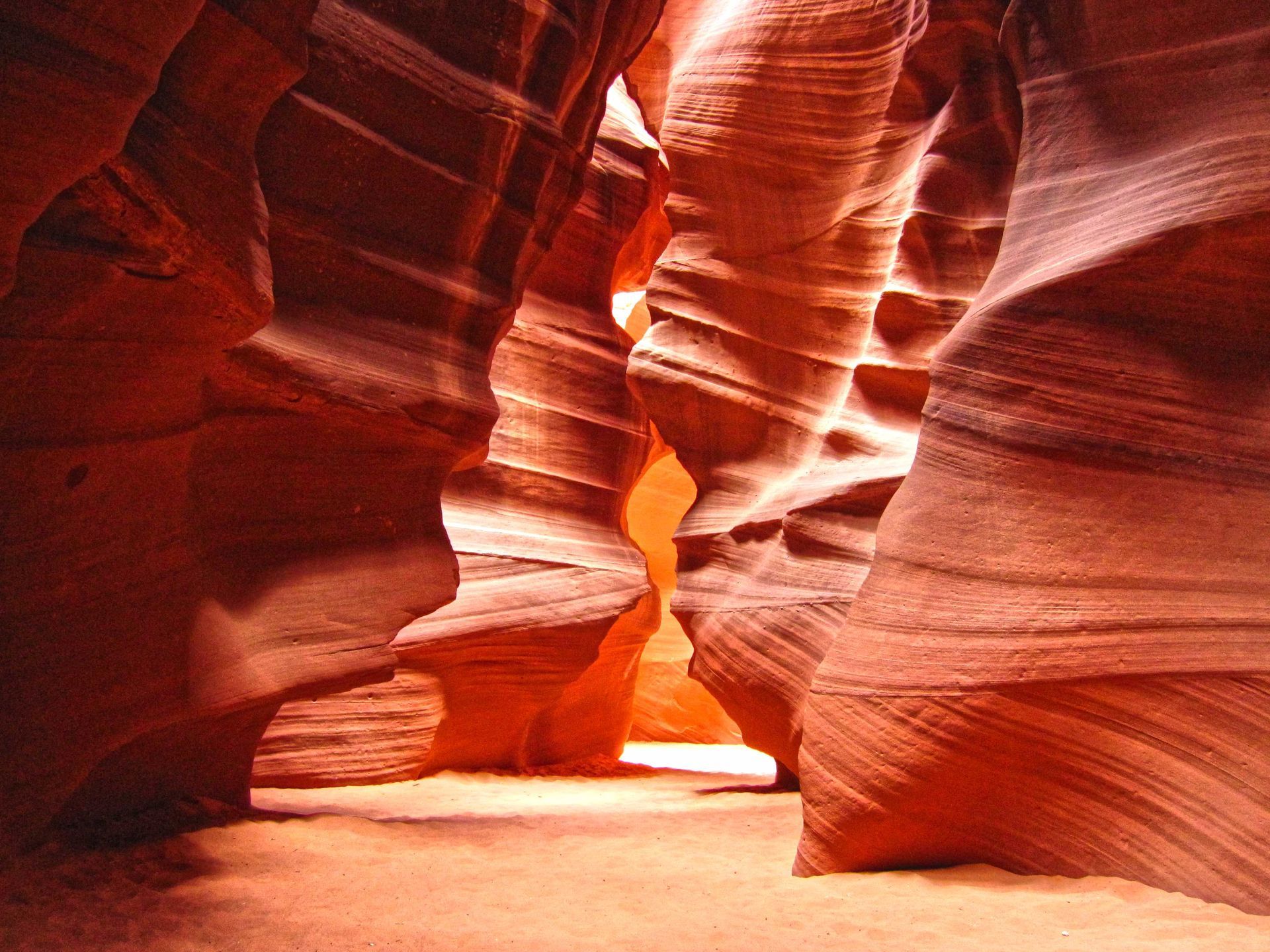 Red sandstone canyon walls with sunlight filtering through.