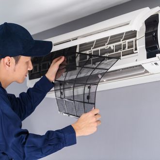 professional HVAC worker maintaining heat pump repair