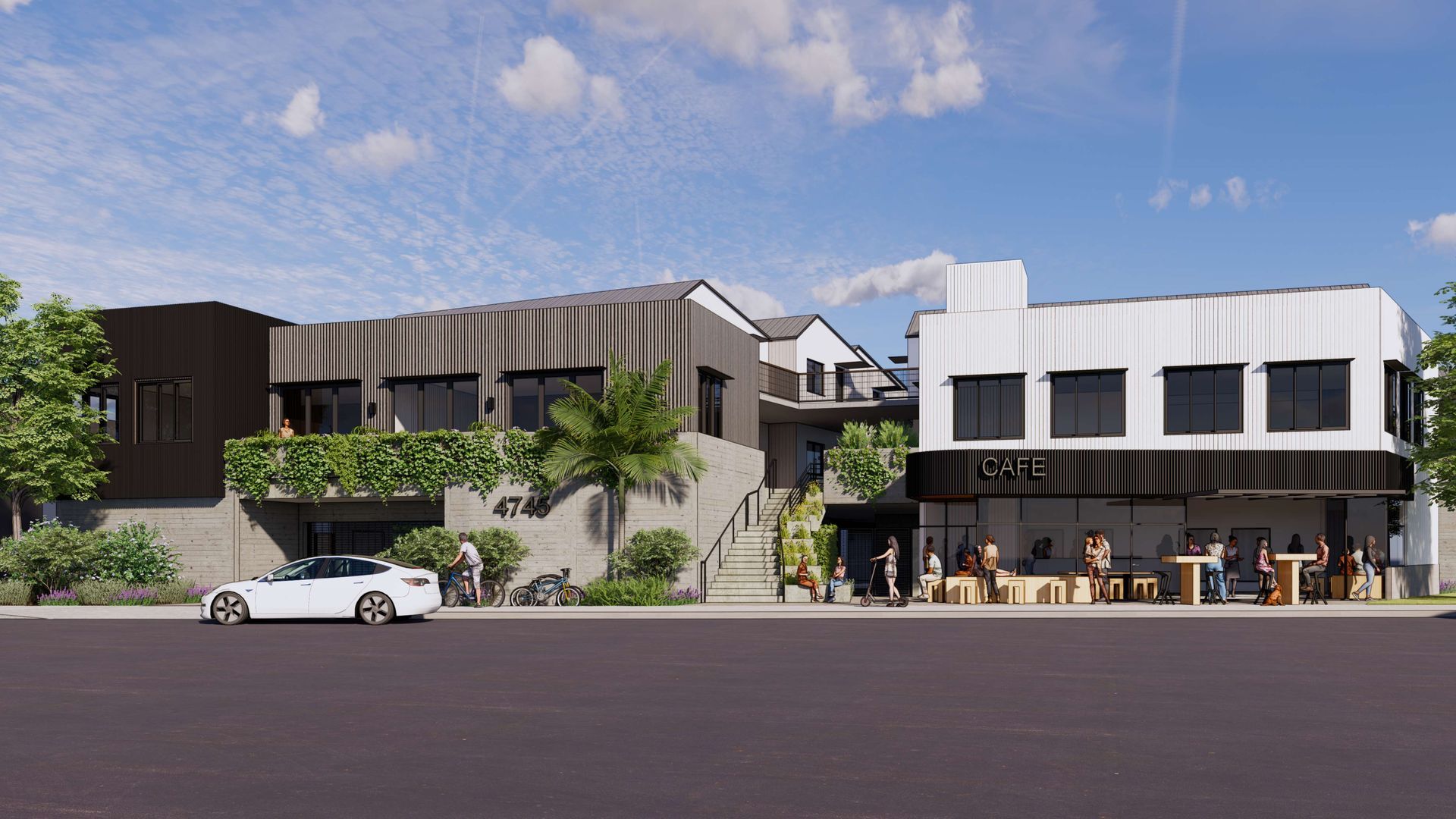 Modern commercial building with two-story sections. People outside, car parked. Gray, black, and white exterior.