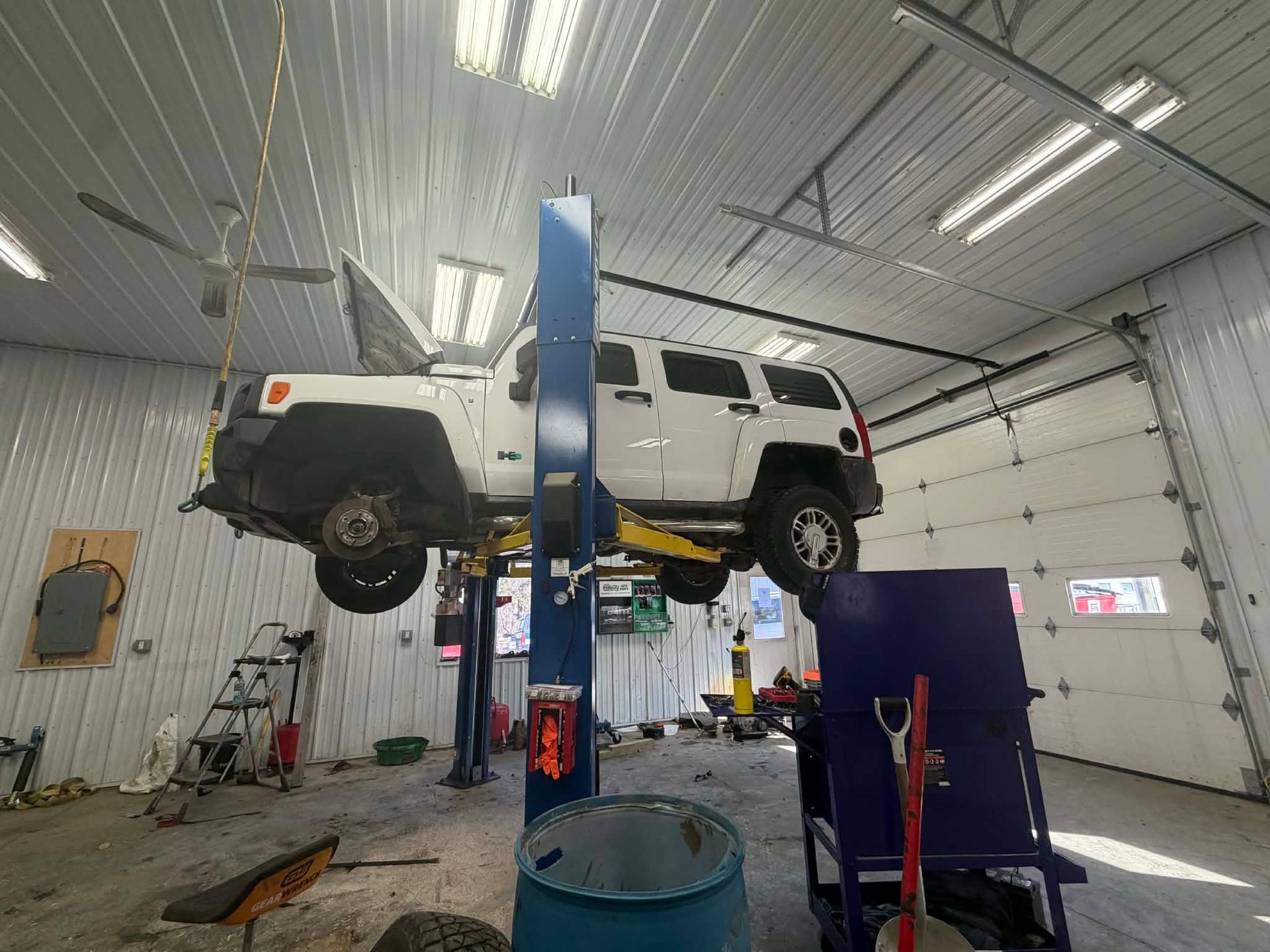 A man is working under a car in a garage.