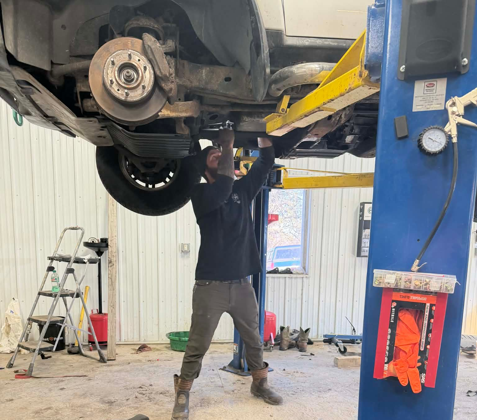 Three men are posing for a picture in front of a red truck.