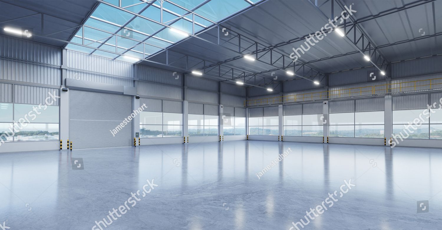 An empty warehouse with a lot of windows and a skylight.
