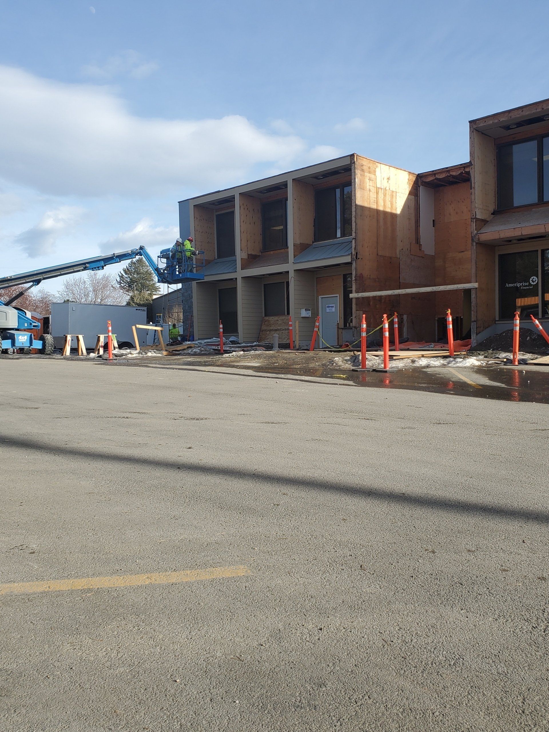 A large building is being built in a parking lot