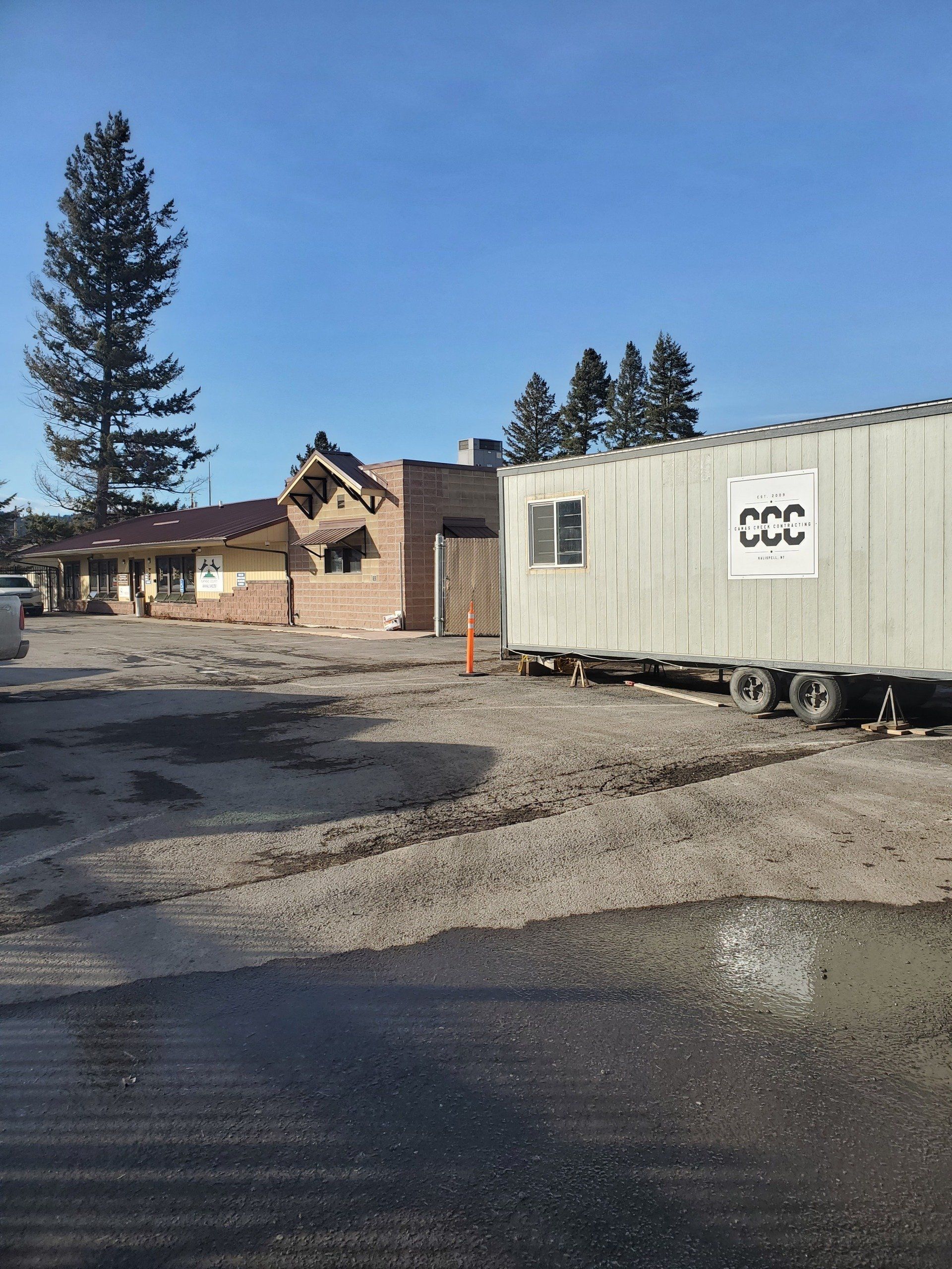 A building under construction with a trailer parked in front of it.