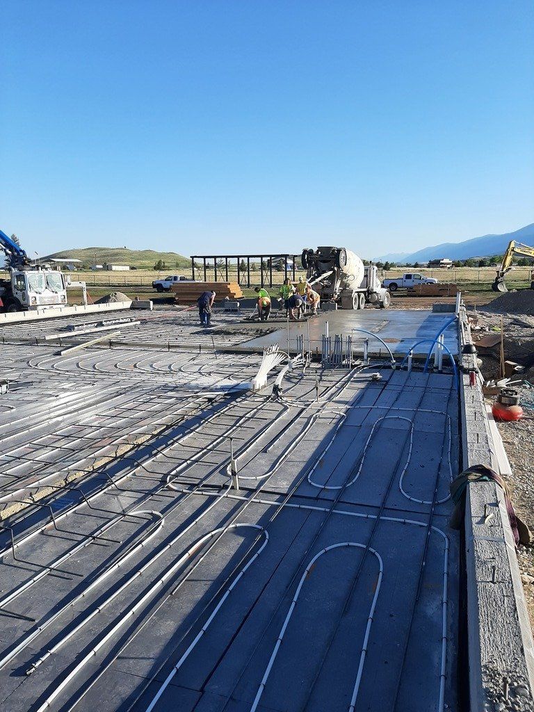 A large concrete slab is being poured on a construction site.