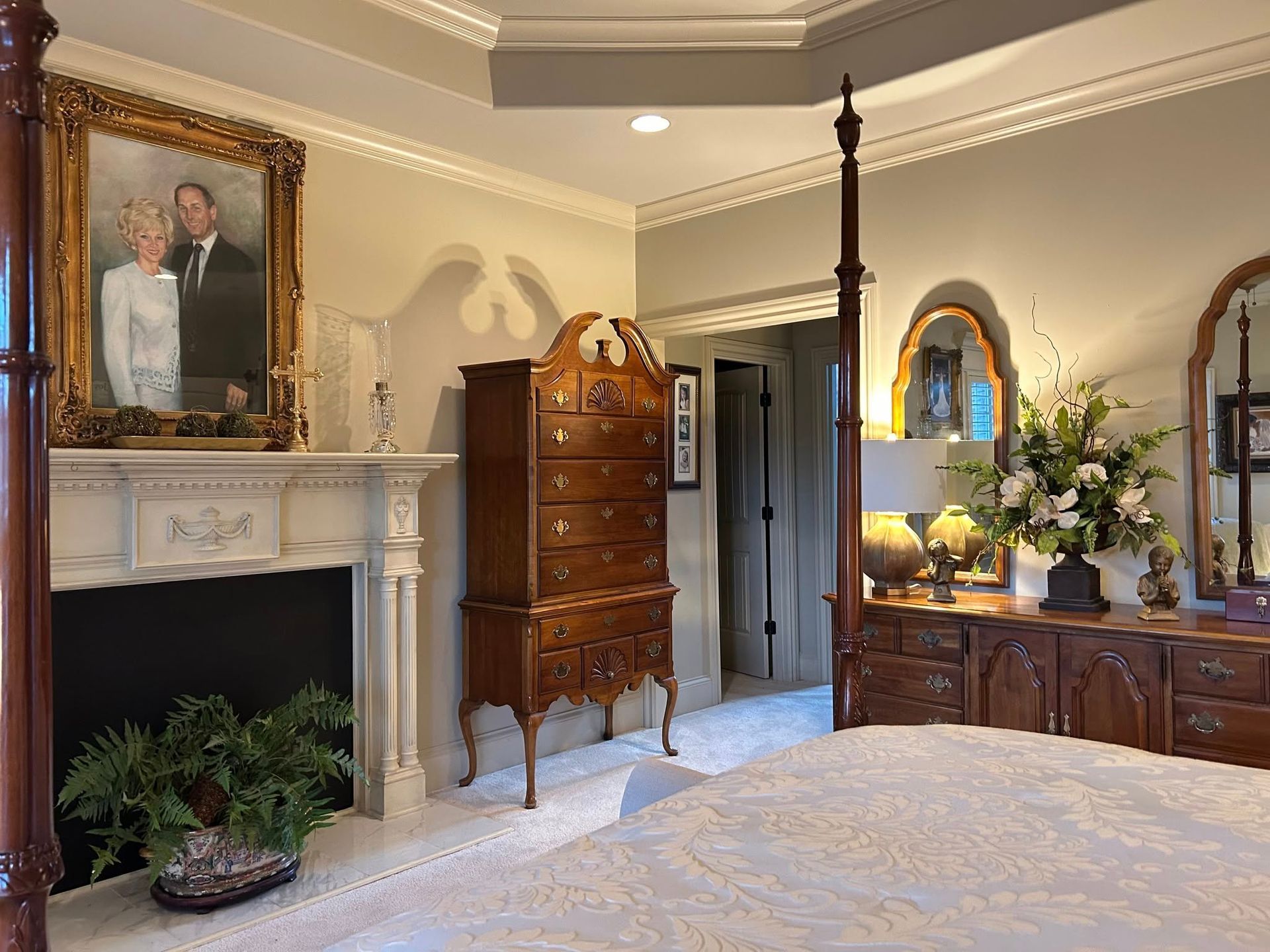A bedroom with a four poster bed and a fireplace