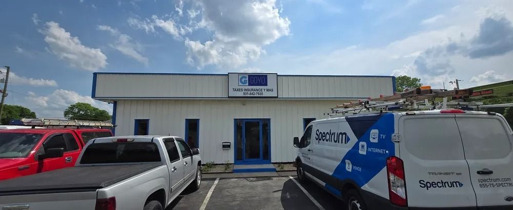 A bunch of trucks and vans are parked in front of a building.