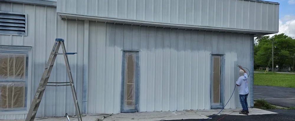 A man is painting the side of a building.