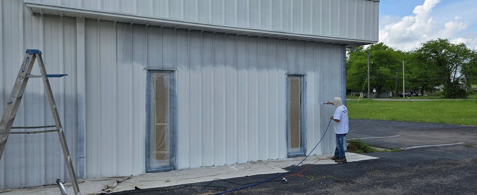 A man is painting the side of a building.