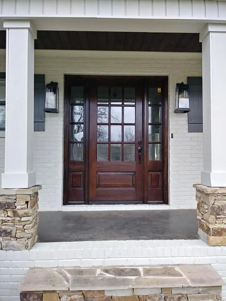The front door of a white house with a wooden door