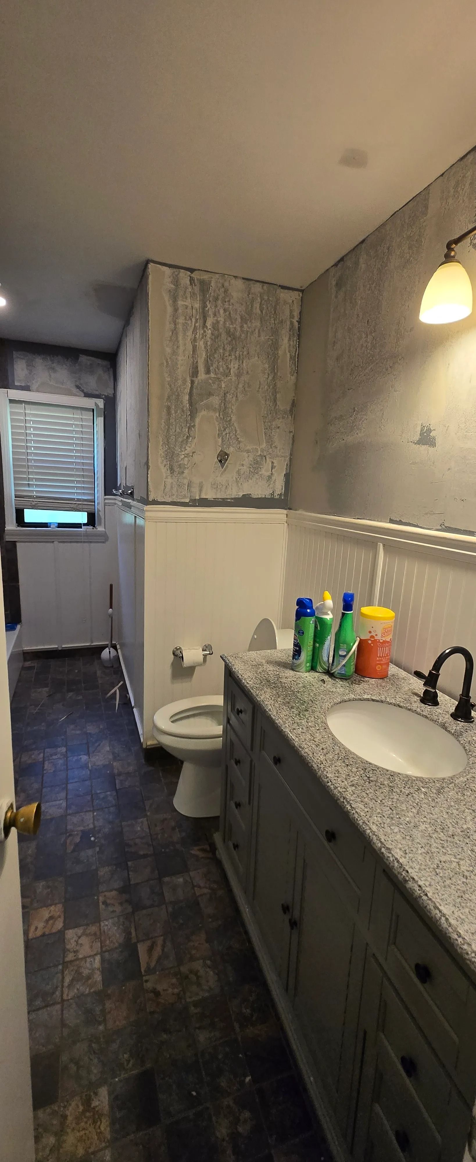 A bathroom with a toilet , sink , and cabinets.