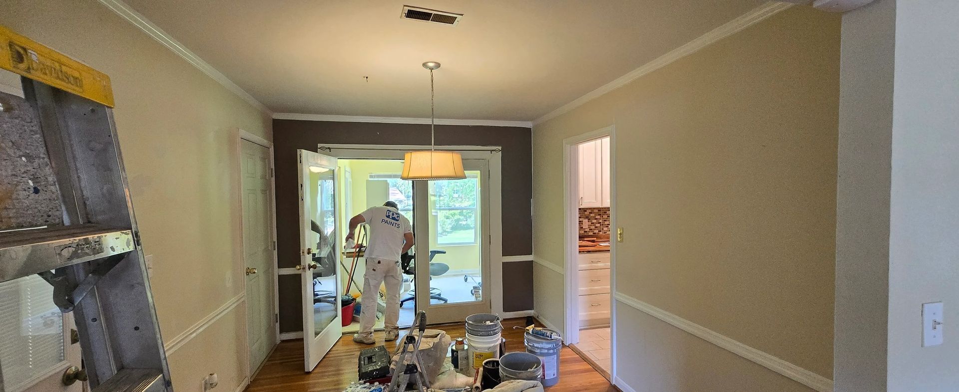A dining room is being painted in a house.