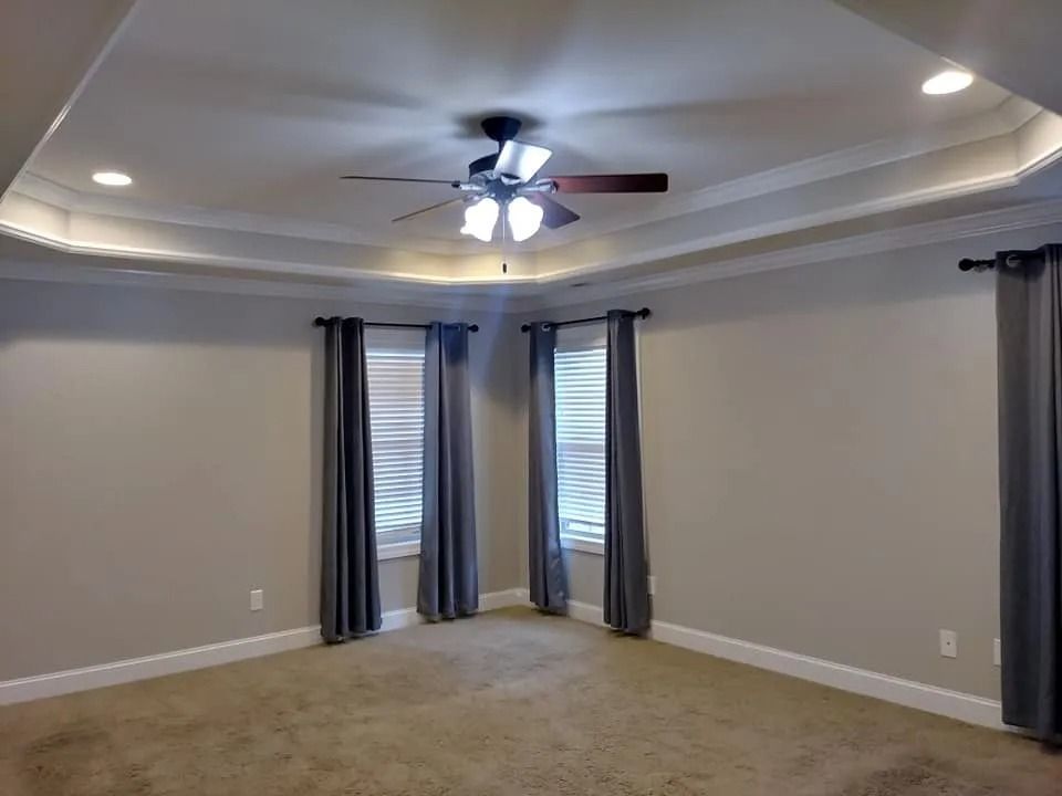 There is a ceiling fan in the corner of the room.