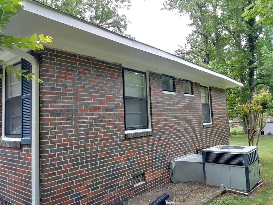 A brick house with a air conditioner on the side of it.