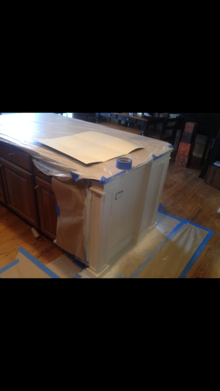 Kitchen island prepared for painting with masking tape and paper.