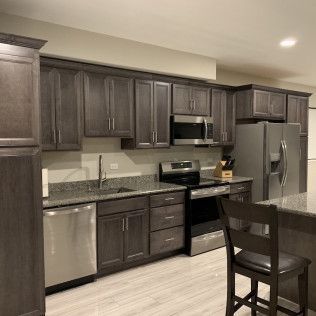 Dark gray kitchen cabinets with stainless steel appliances and a granite countertop.