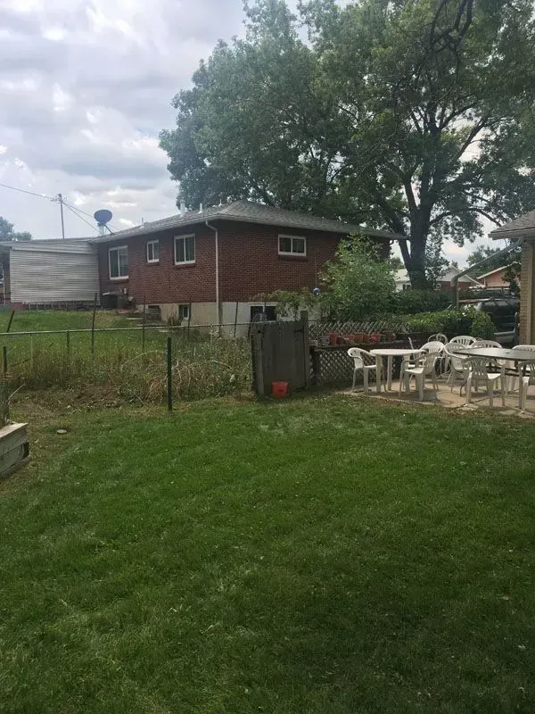 Cluttered basement with window. Various items piled around including a table, barrel, and painting.