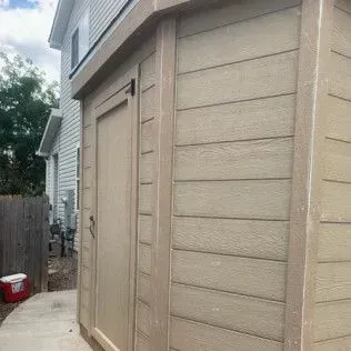 Bedroom with wrought iron bed frame, floral quilt, and artwork on cream-colored walls.