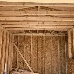 Interior of a wood-framed structure, walls and ceiling, under construction.