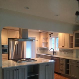 Kitchen with island, stainless steel appliances, light wood cabinets, and granite countertops.
