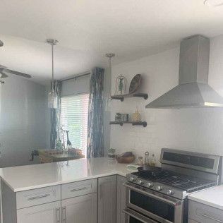 Kitchen with white countertops, stainless steel appliances, and gray cabinets.