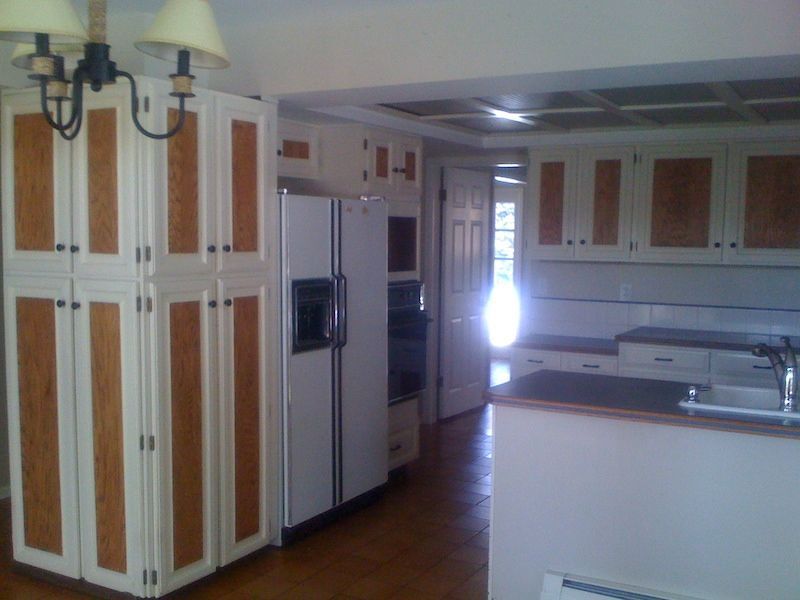 Kitchen with white cabinets, wood accents, appliances, and island.