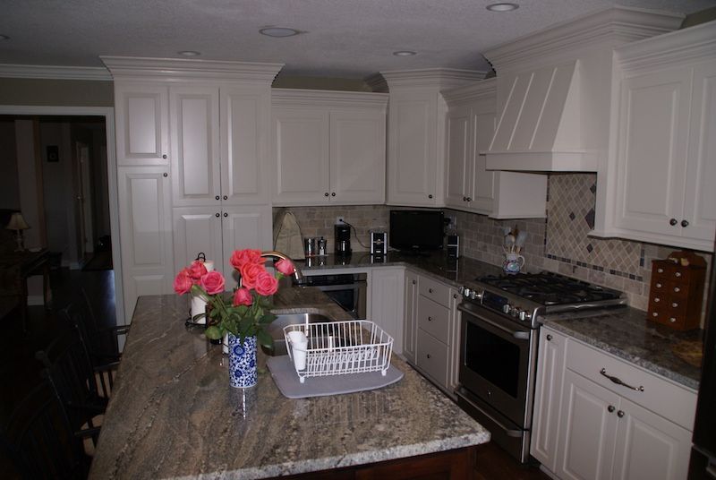 Kitchen with white cabinets, granite countertops, and a stove.